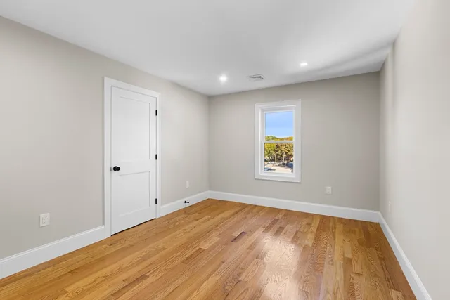 a view of room with window and wooden floor