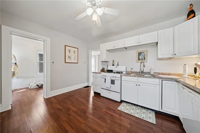 a kitchen with granite countertop white cabinets and white appliances