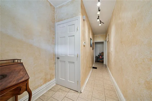 a view of a hallway with closet and a livingroom with furniture
