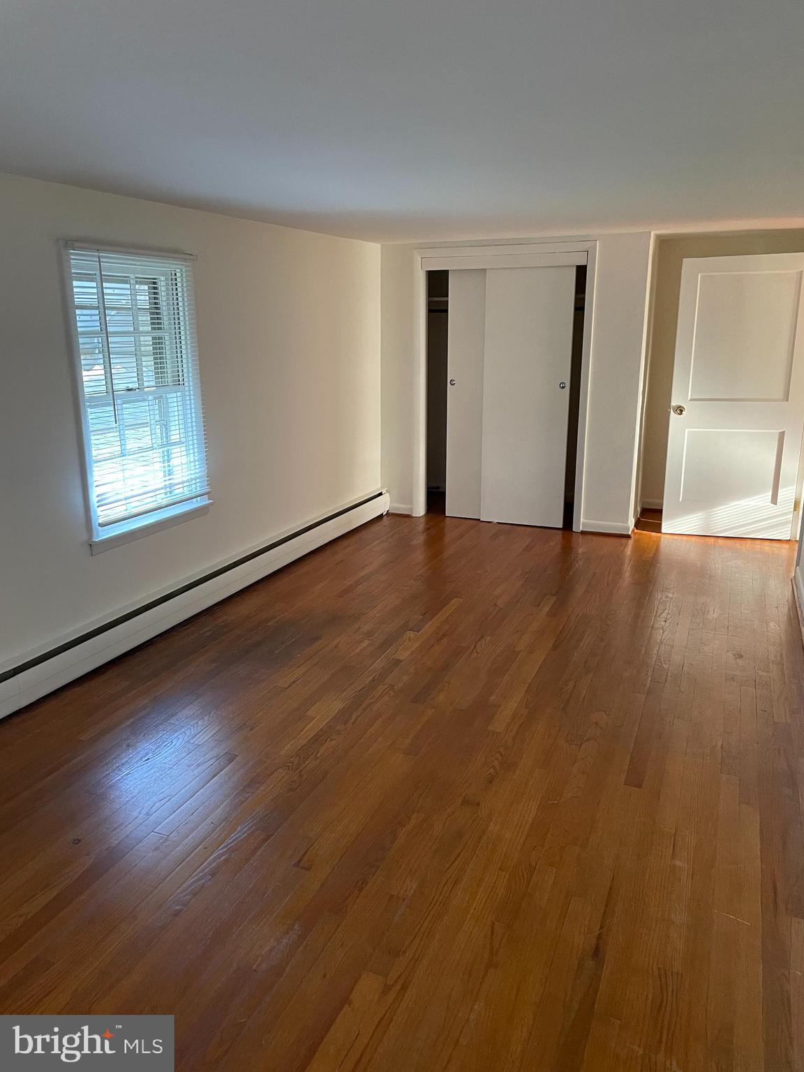 10524 Stull Road Thurmont, MD 21788 - Photo 64 of 91 a view of an empty room with wooden floor and a window