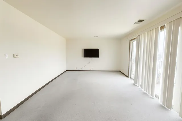 an empty room with a empty space and windows
