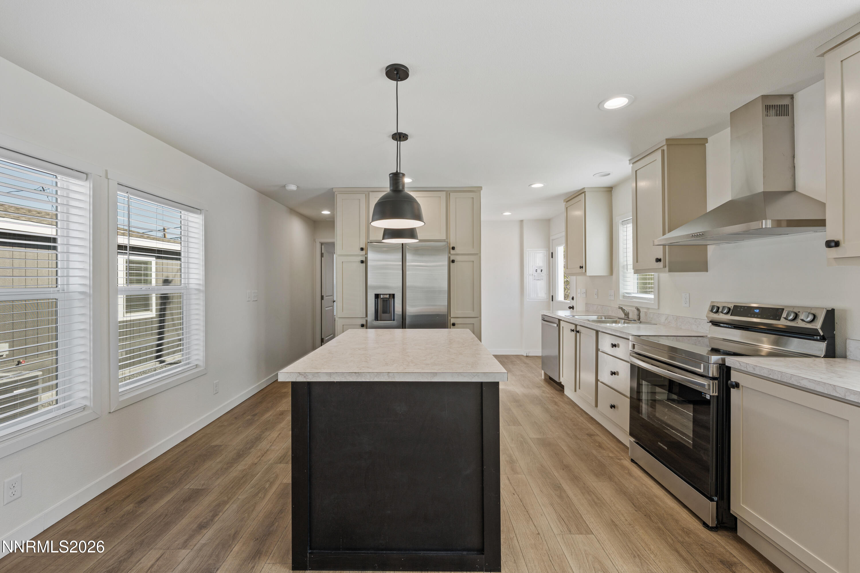 105 Fireman Row Dayton, NV 89403 - Photo 5 of 16 a kitchen with stainless steel appliances granite countertop a stove a sink dishwasher a refrigerator and white cabinets with wooden floor