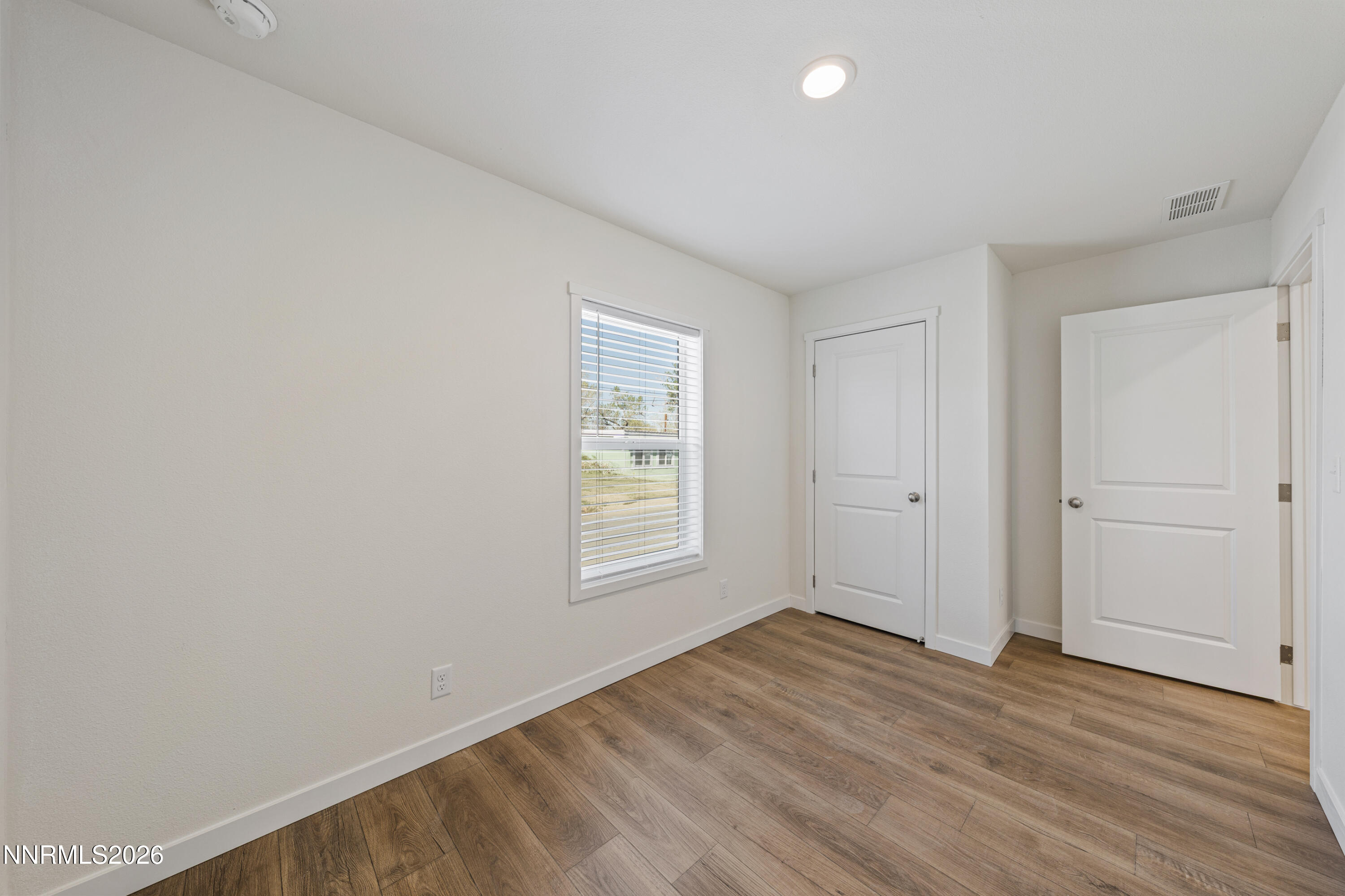 105 Fireman Row Dayton, NV 89403 - Photo 9 of 16 an empty room with wooden floor and windows