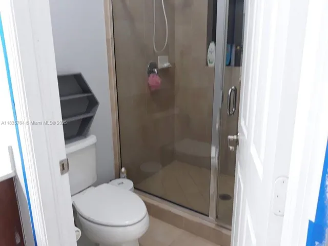a bathroom with a toilet and a shower