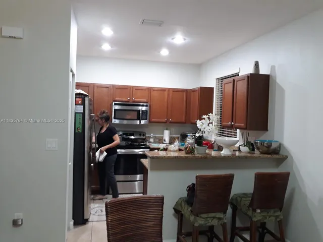 a kitchen with a sink refrigerator and cabinets
