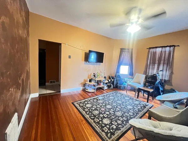 a living room with rug floor and a flat screen tv