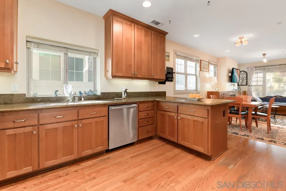 445 E Avenue Coronado, CA 92118 - Photo 5 of 25 a kitchen with stainless steel appliances granite countertop wooden cabinets a stove a sink a dining table and chairs