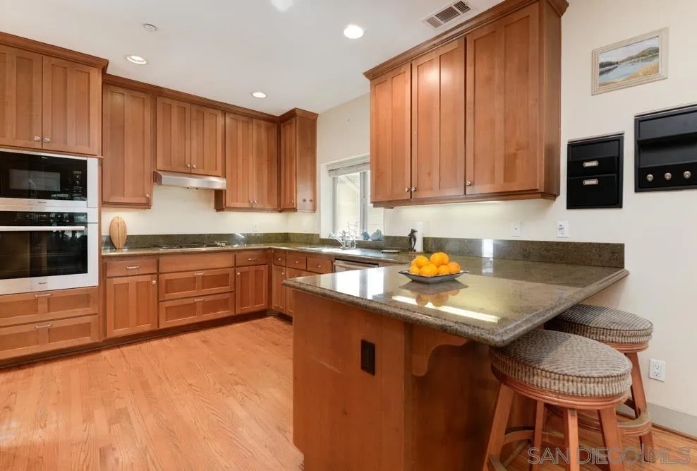 445 E Avenue Coronado, CA 92118 - Photo 7 of 25 a kitchen with stainless steel appliances granite countertop wooden cabinets a stove top oven a sink and dishwasher