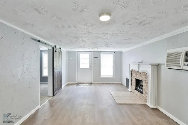 a view of an empty room with a fireplace and a window