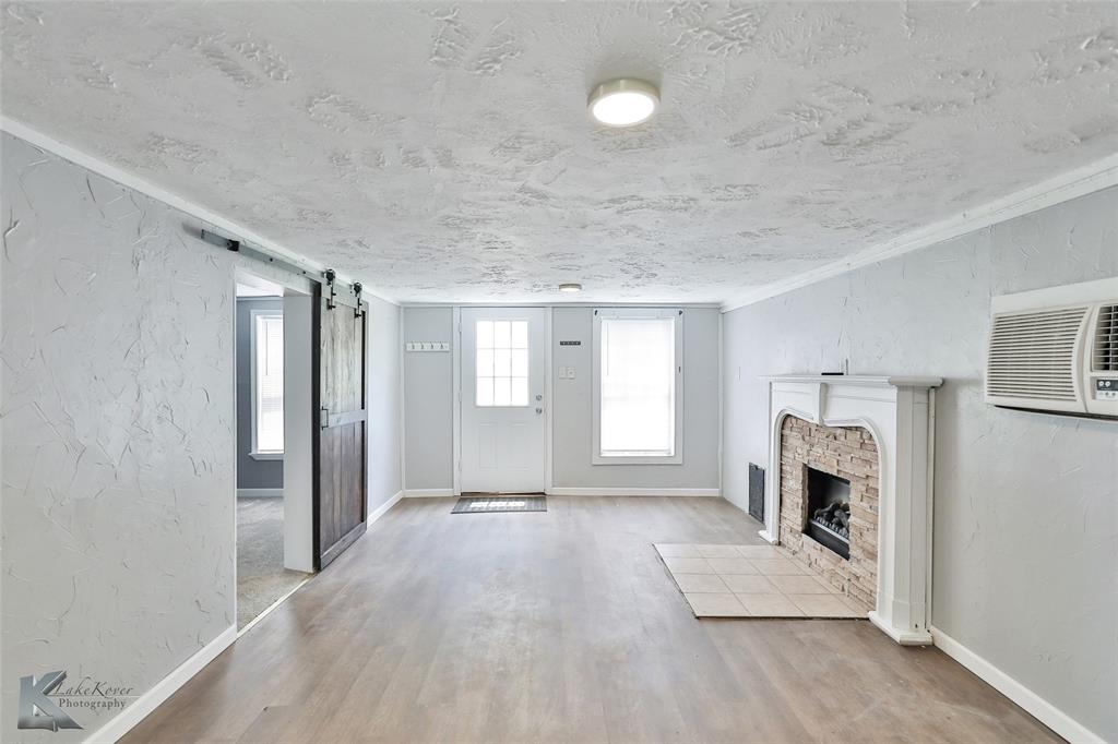 377 Grisham Road Haskell, TX 79521 - Photo 12 of 37 a view of an empty room with a fireplace and a window