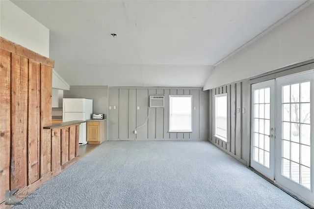 a kitchen with white cabinets and refrigerator