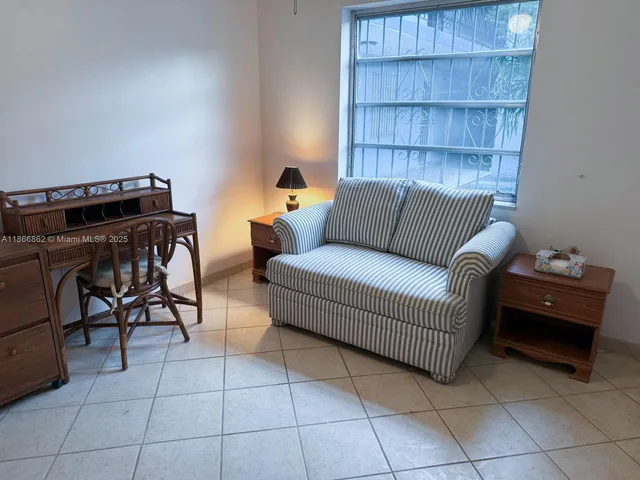 a living room with furniture a piano and a bookshelf