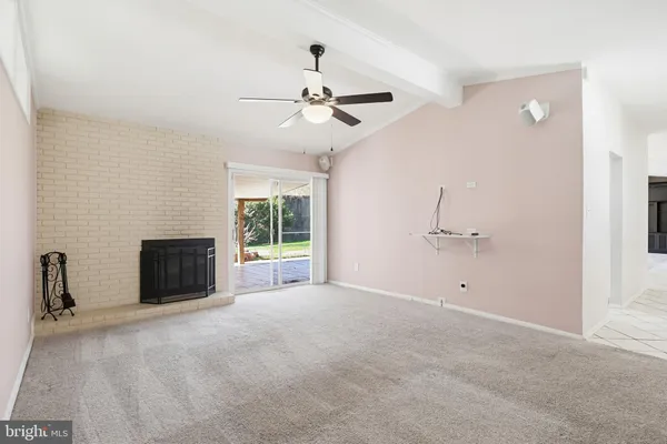 a view of a livingroom with a fireplace and a ceiling fan