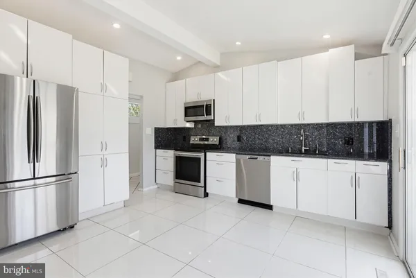 a kitchen with stainless steel appliances granite countertop a refrigerator and a stove top oven