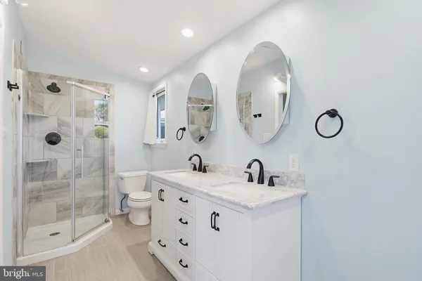 a bathroom with a double vanity sink mirror double shower and a mirror