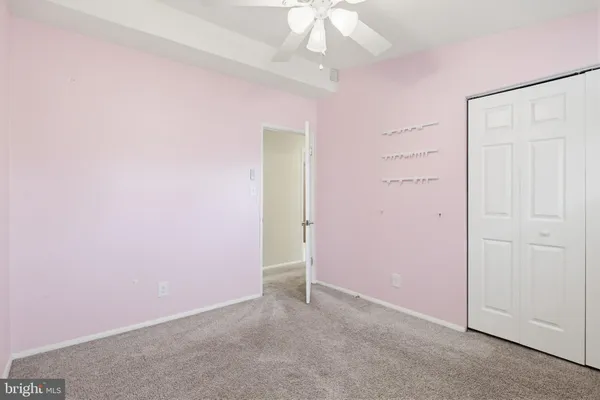 an empty room with a chandelier fan
