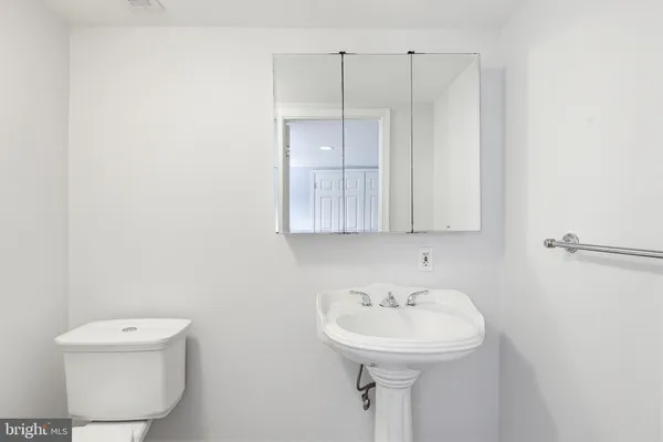 a bathroom with a sink a toilet and mirror