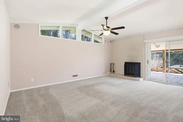 an empty room with ceiling fan and window