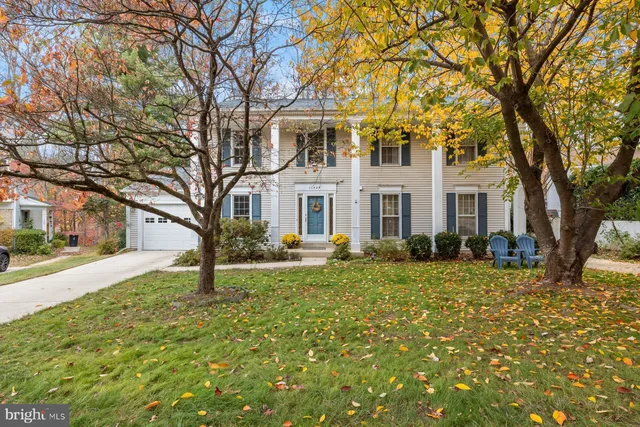 a front view of a house with a large tree