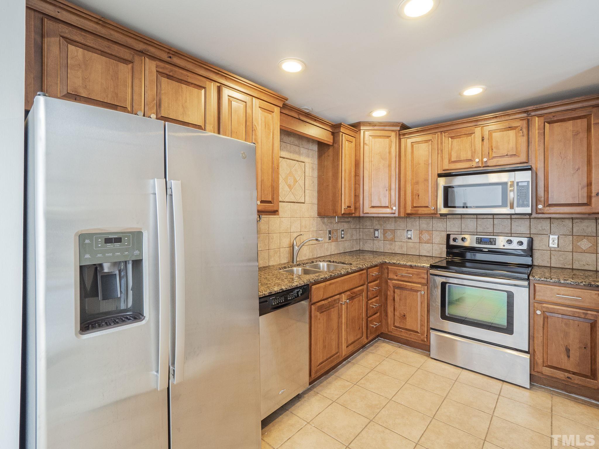 5072 Flint Ridge Place, Unit 5072 Raleigh, NC 27609 - Photo 7 of 18 a kitchen with granite countertop stainless steel appliances a sink cabinets and a window