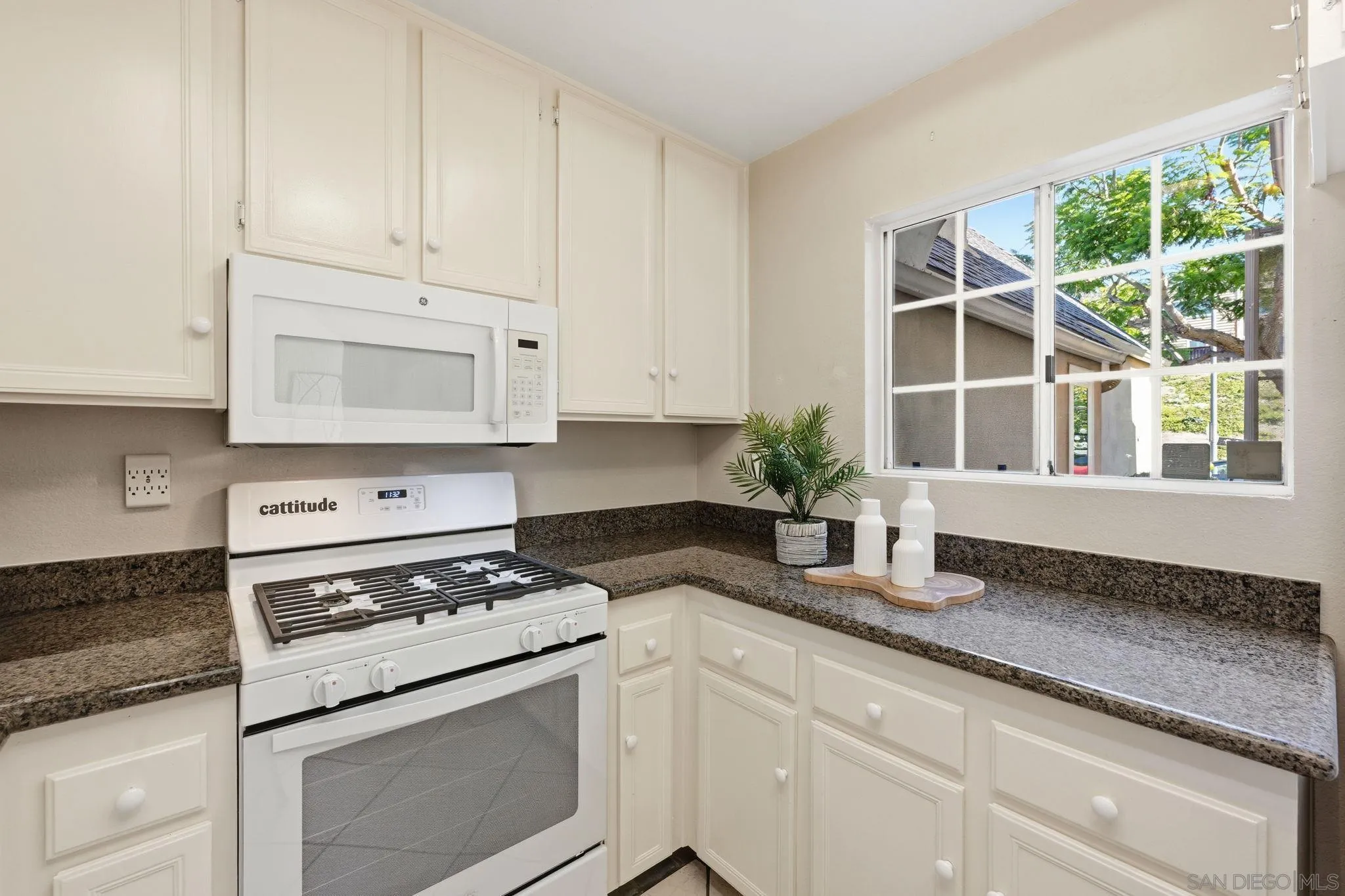 2591 Regent Road Carlsbad, CA 92010 - Photo 13 of 34 a kitchen with granite countertop white cabinets and white appliances