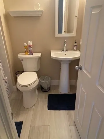 a bathroom with a sink toilet and a mirror