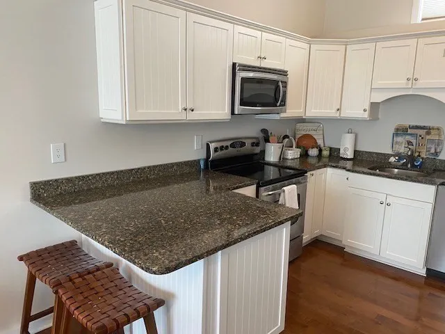 a kitchen with stainless steel appliances granite countertop a sink stove and microwave