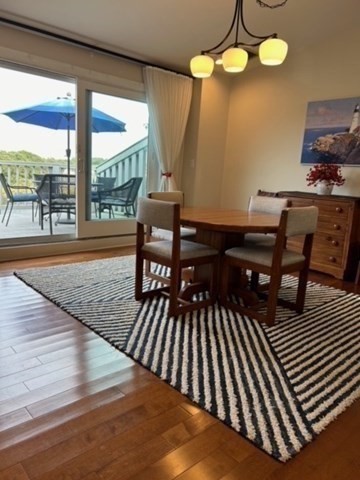 45 Main Street, Unit 221 Wareham, MA 02571 - Photo 27 of 36 a view of a dining room with furniture wooden floor and chandelier
