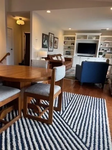 a living room with furniture a flat screen tv and kitchen view