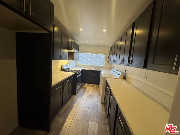 a kitchen with a sink and wooden floor