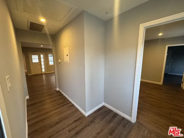 a view of a hallway with wooden floor
