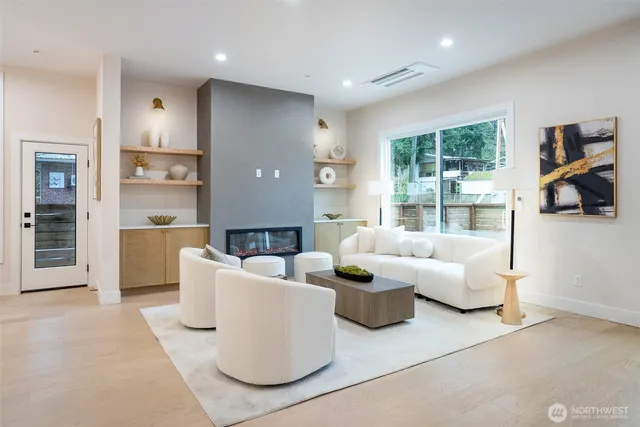 a living room with fireplace furniture and a large window