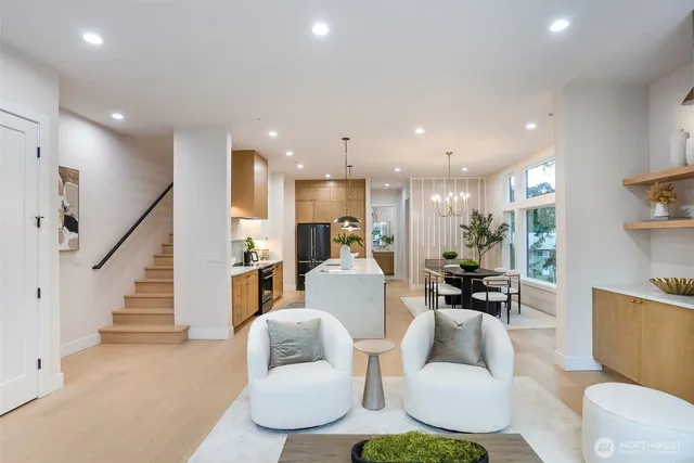 a living room with furniture kitchen and a wooden floor