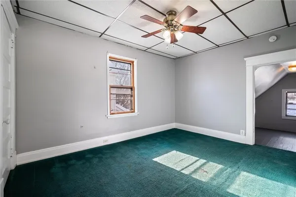 a view of an empty room with a window and fan