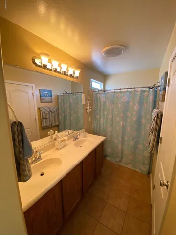 a bathroom with a granite countertop sink a mirror and a shower