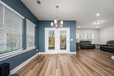 a view of a room with wooden floor fireplace and windows