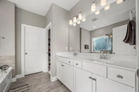 a bathroom with a double vanity sink and a mirror