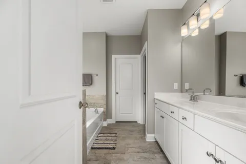 a spacious bathroom with a granite countertop sink and a mirror