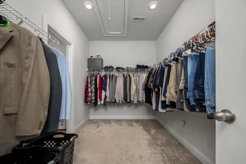 a view of walk in closet with clothes