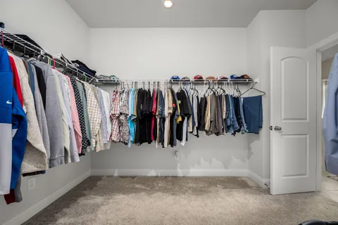a view of walk in closet with clothes