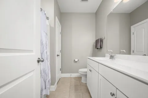 a bedroom with a bed and a lamp on the dresser