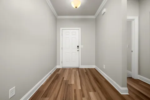 a view of a room with wooden floor and small window