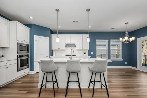 a kitchen with stainless steel appliances granite countertop a kitchen island hardwood floor sink and stove