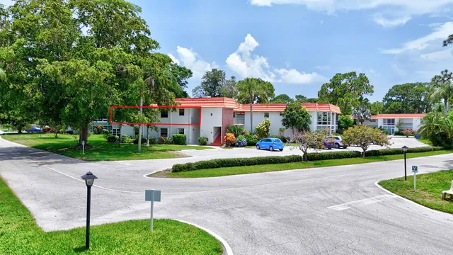 a front view of a house with a yard and potted plants