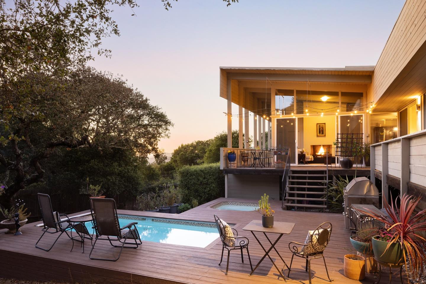 a view of a patio with table and chairs a barbeque with wooden floor and fence