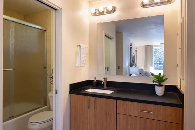 a bathroom with a granite countertop sink and a mirror