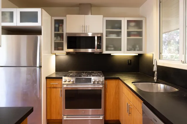 a kitchen with stainless steel appliances granite countertop a sink stove and microwave
