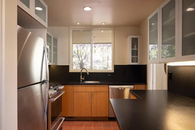 a kitchen with stainless steel appliances a refrigerator sink stove microwave and cabinets