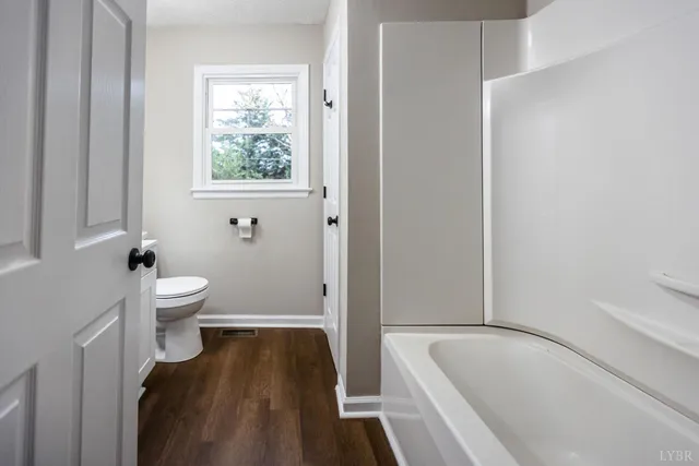 a bathroom with a tub and toilet