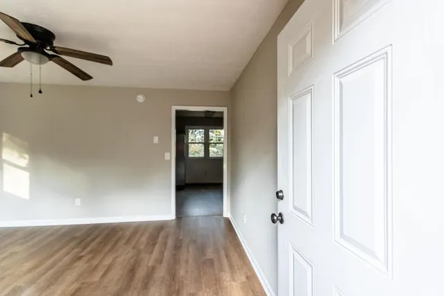 a view of a room with wooden floor staircase and a ceiling fan